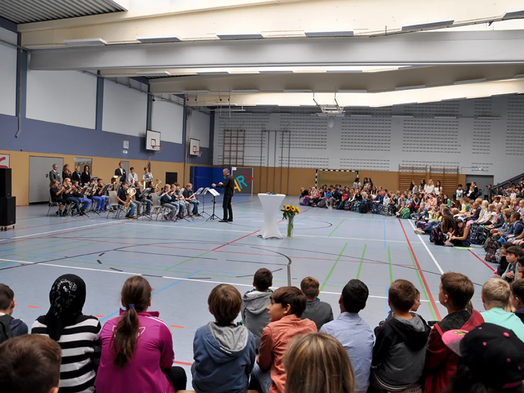 Blick von der Seite über die Feier in der Sporthalle.